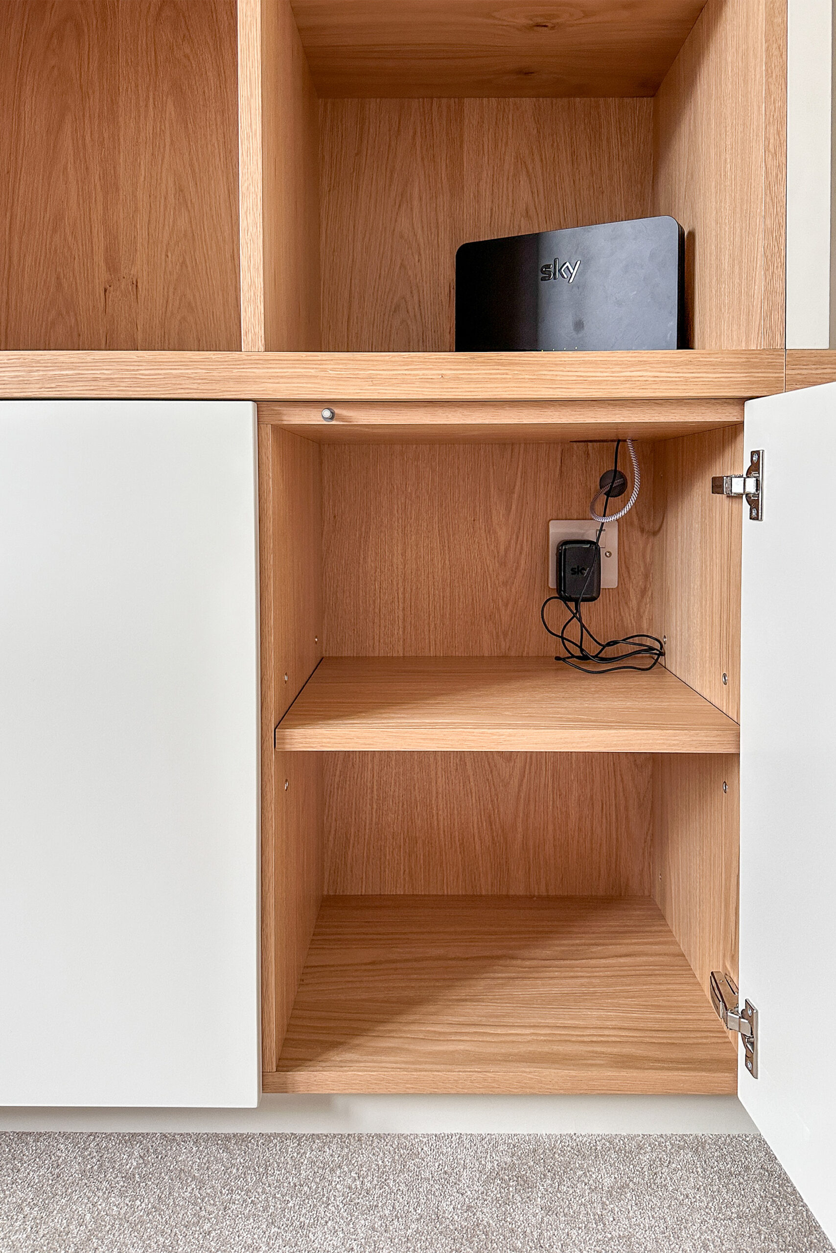Project: Media Wall Asymmetric Design 2 A bespoke Media wall with a dedicated cubby for the wireless route. Power supply and cabling hidden into the cabinet below for a neat and tidy finish.