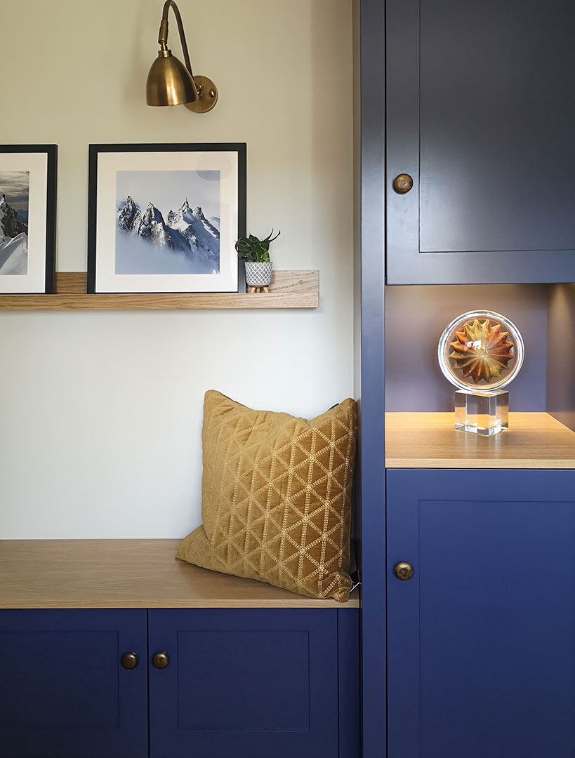 A bespoke home office, with floor to ceiling storage alongside a bench seat and picture shelf.