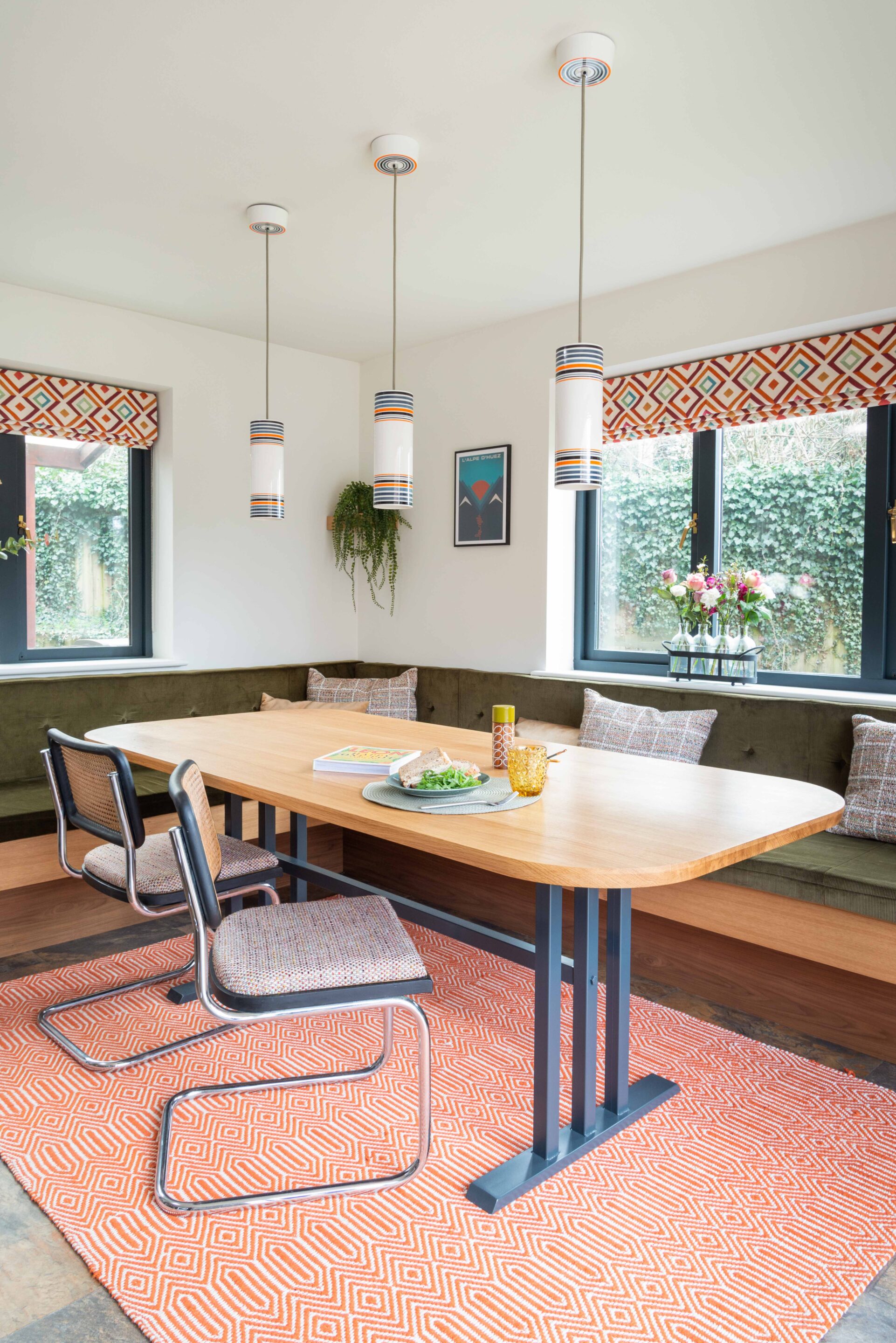 Bespoke dining table with banquette seating and pendant lights over