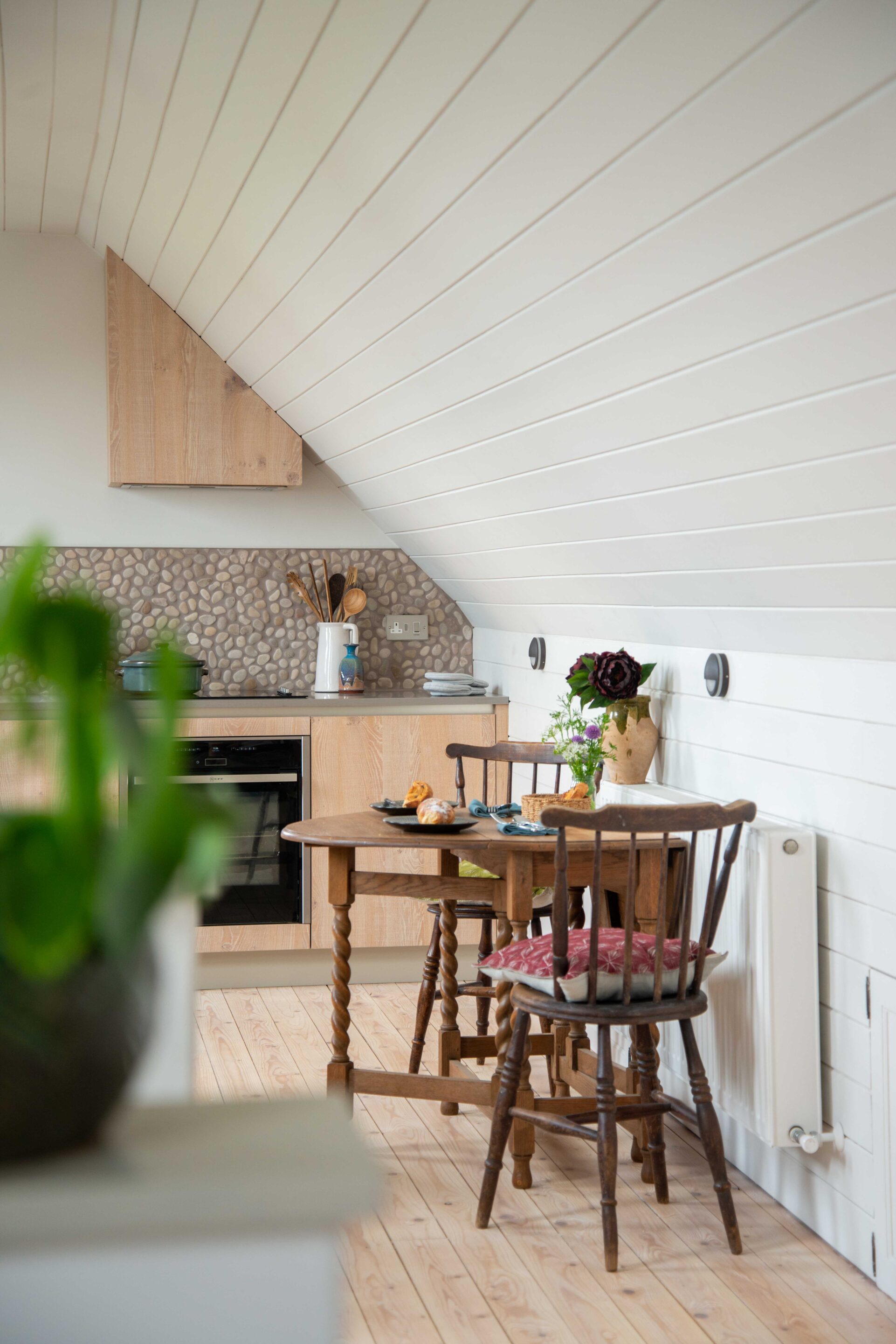 A small, vintage dining table with twisted legs in a converted loft studio