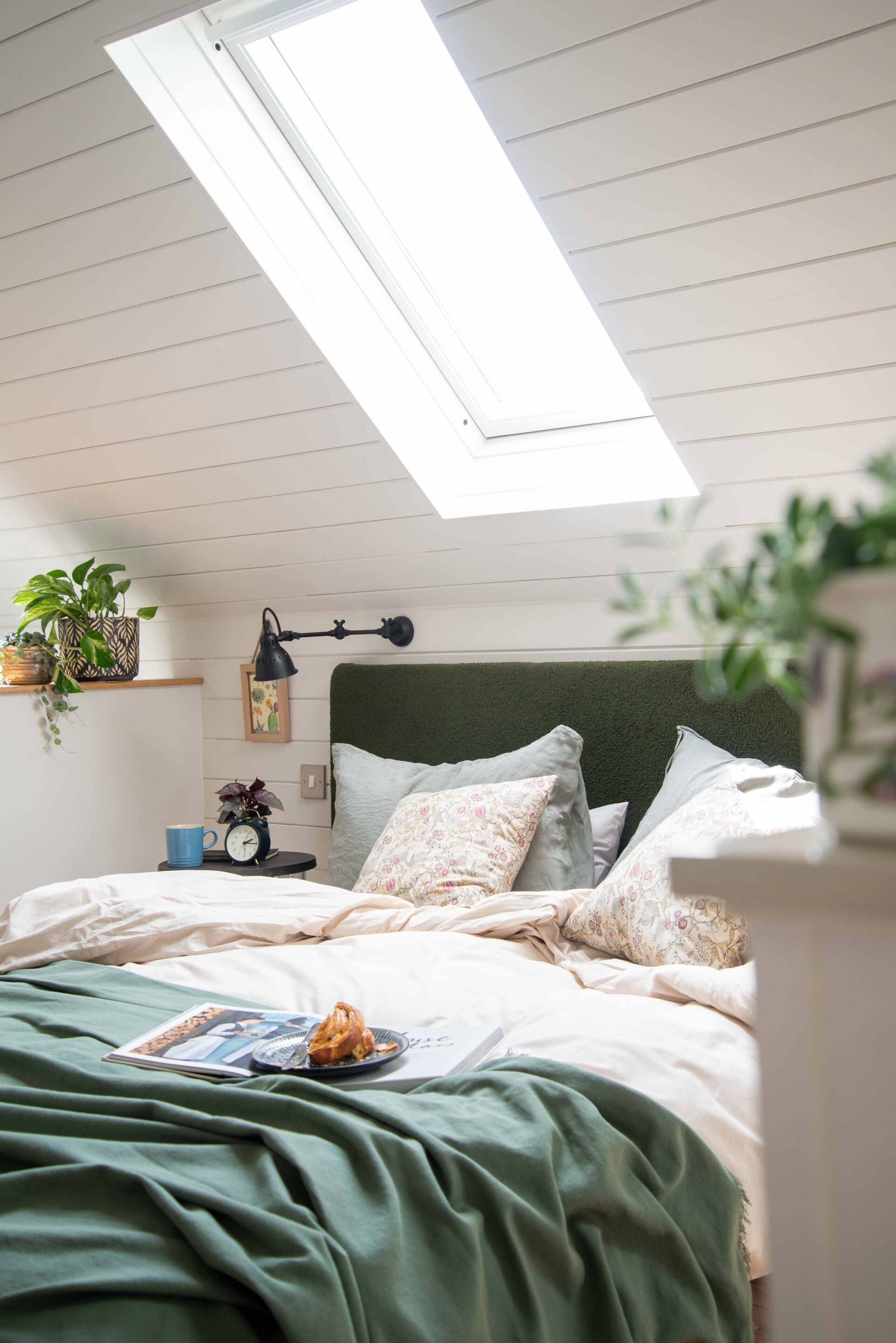 An unmade bed with linen sheets set against white wall panelling