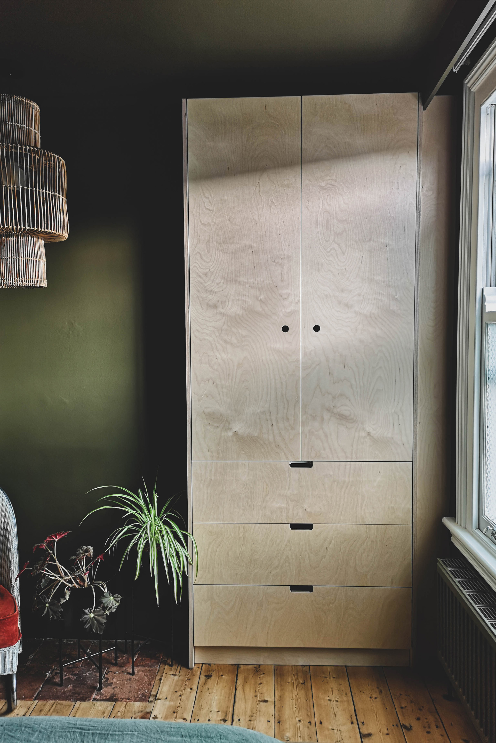 The picture shows bespoke wardrobes made from Birch veneered Plywood, fitting snugly into the recess beside the chimney breast.