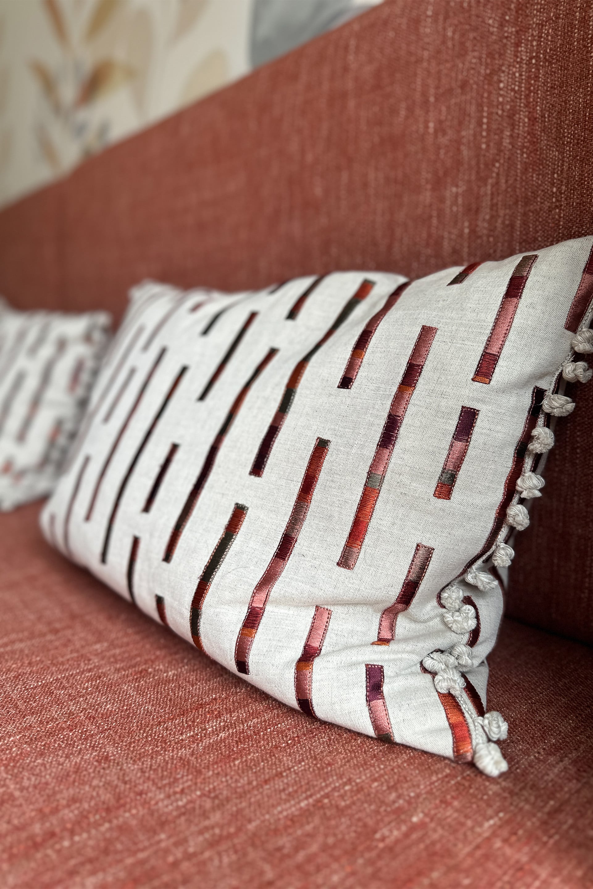 a close up of a cushion made in villa nova fabric with bobble detailing on a bespoke dining bench seat