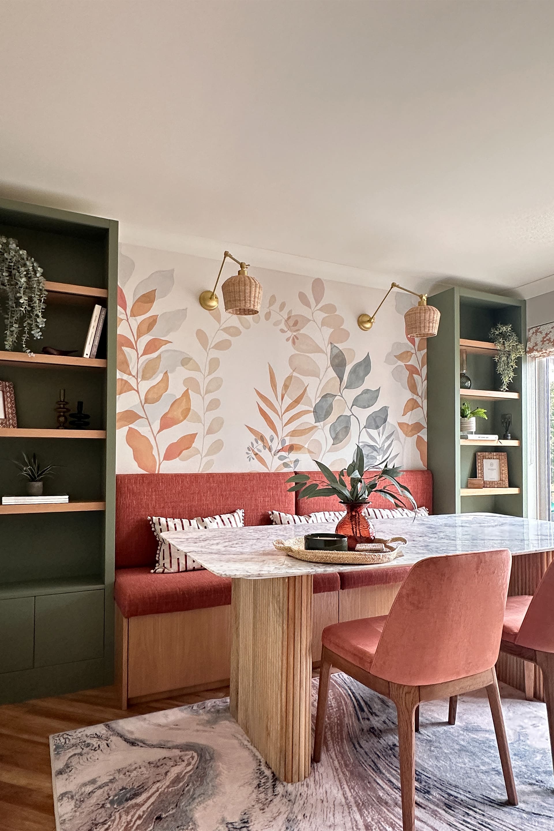 a dining table with upholstered chairs and a bespoke bench seat with book cases either side