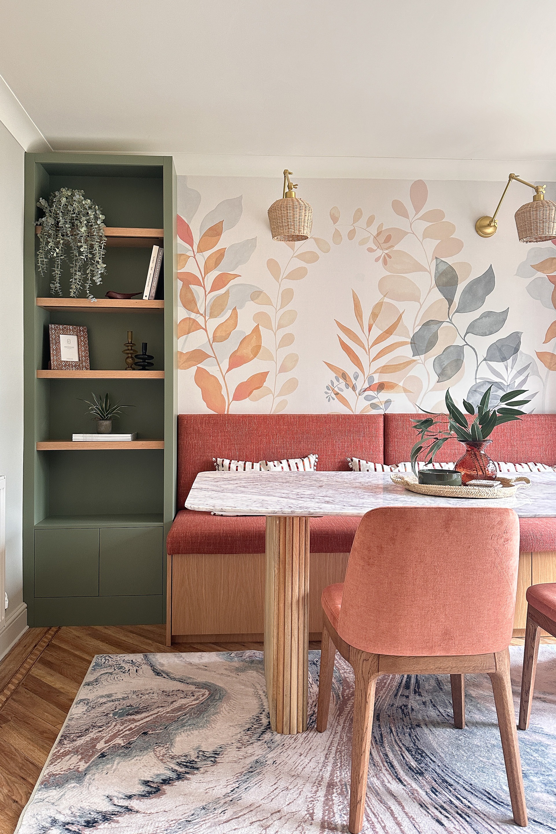 a dining table with upholstered chairs and bespoke bench seat with a wall mural in the background