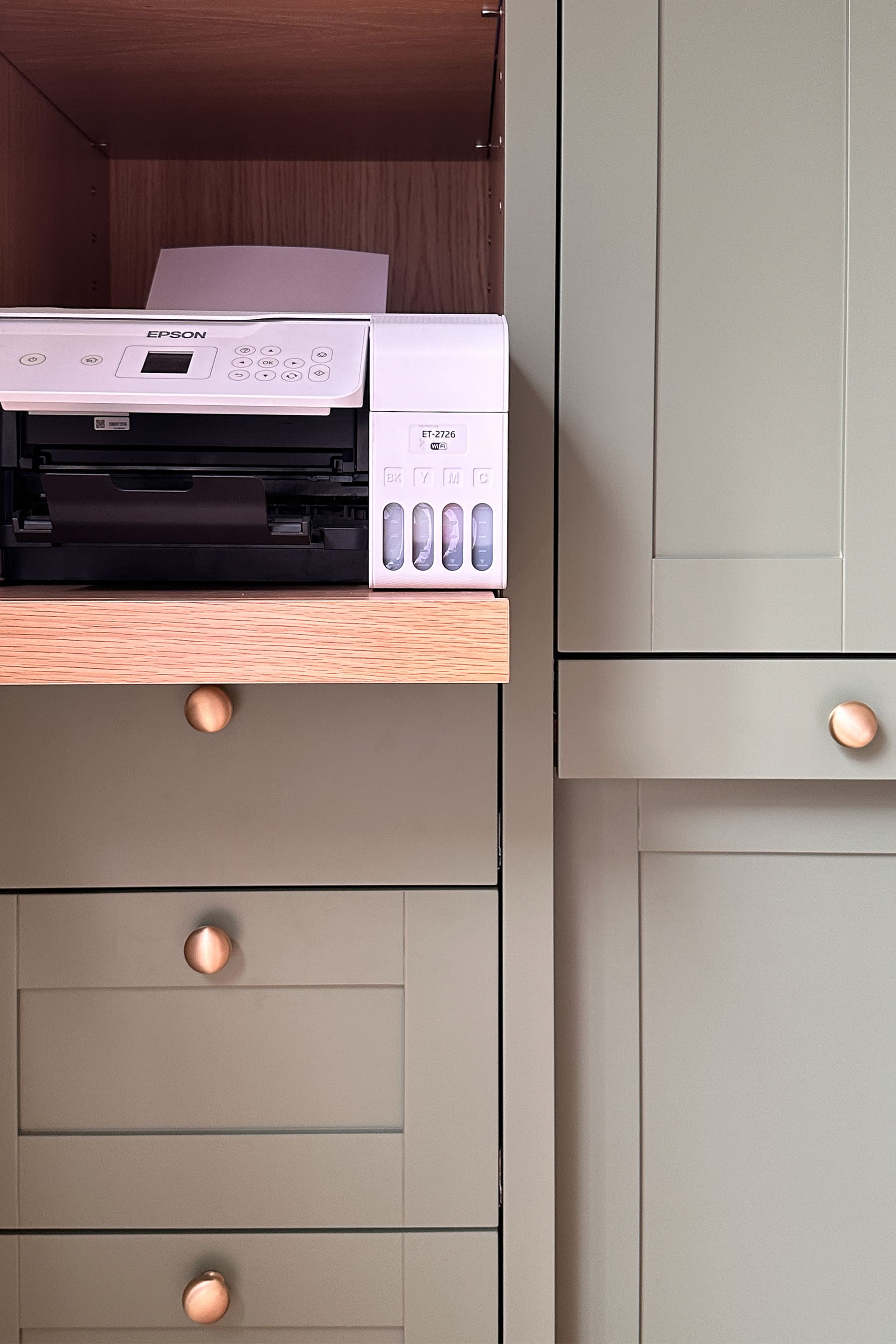 a printer on a pull-out shelf which is part of the bespoke office furniture