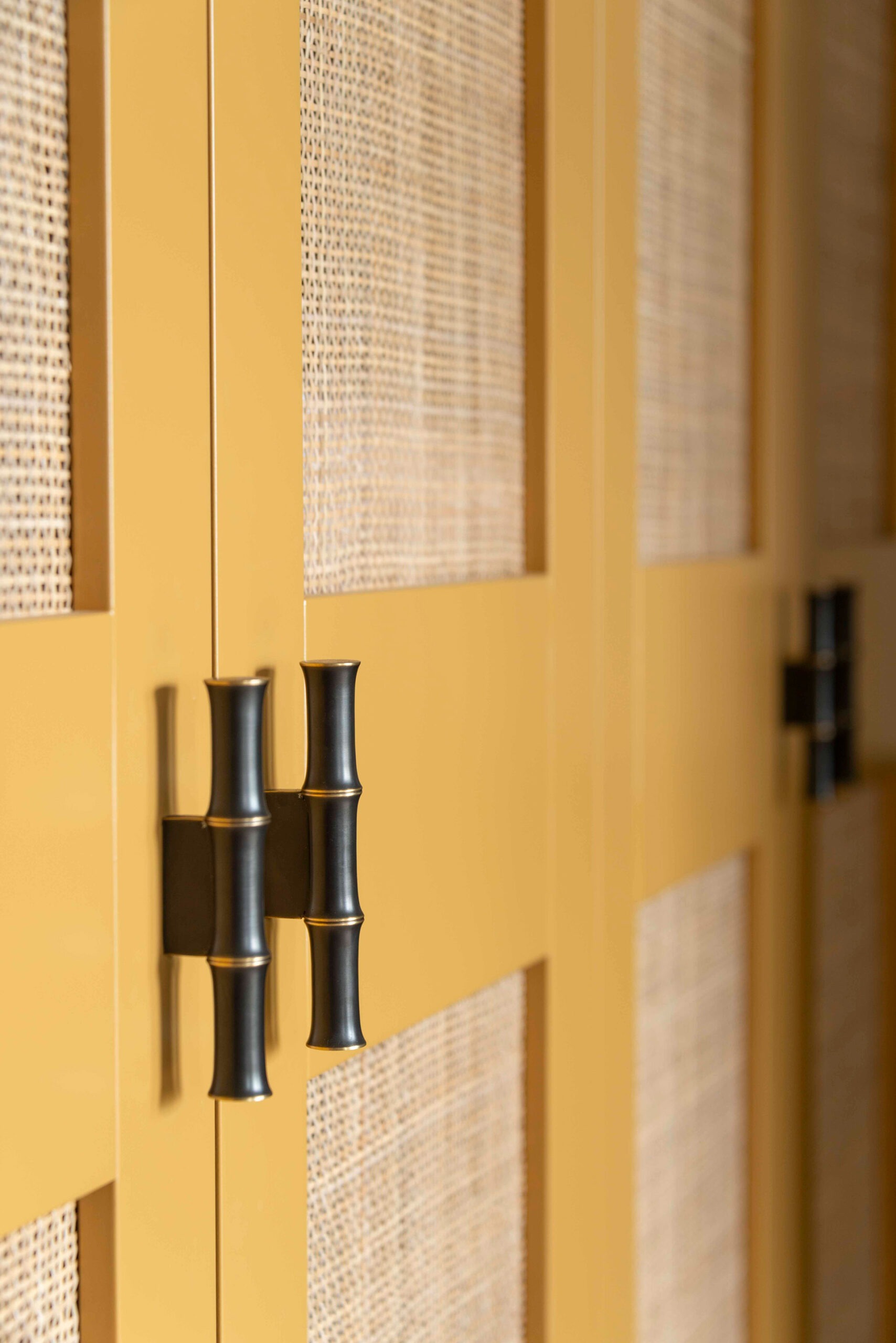 Beautiful bamboo effect handles on a bespoke linen cupboard with rattan doors.