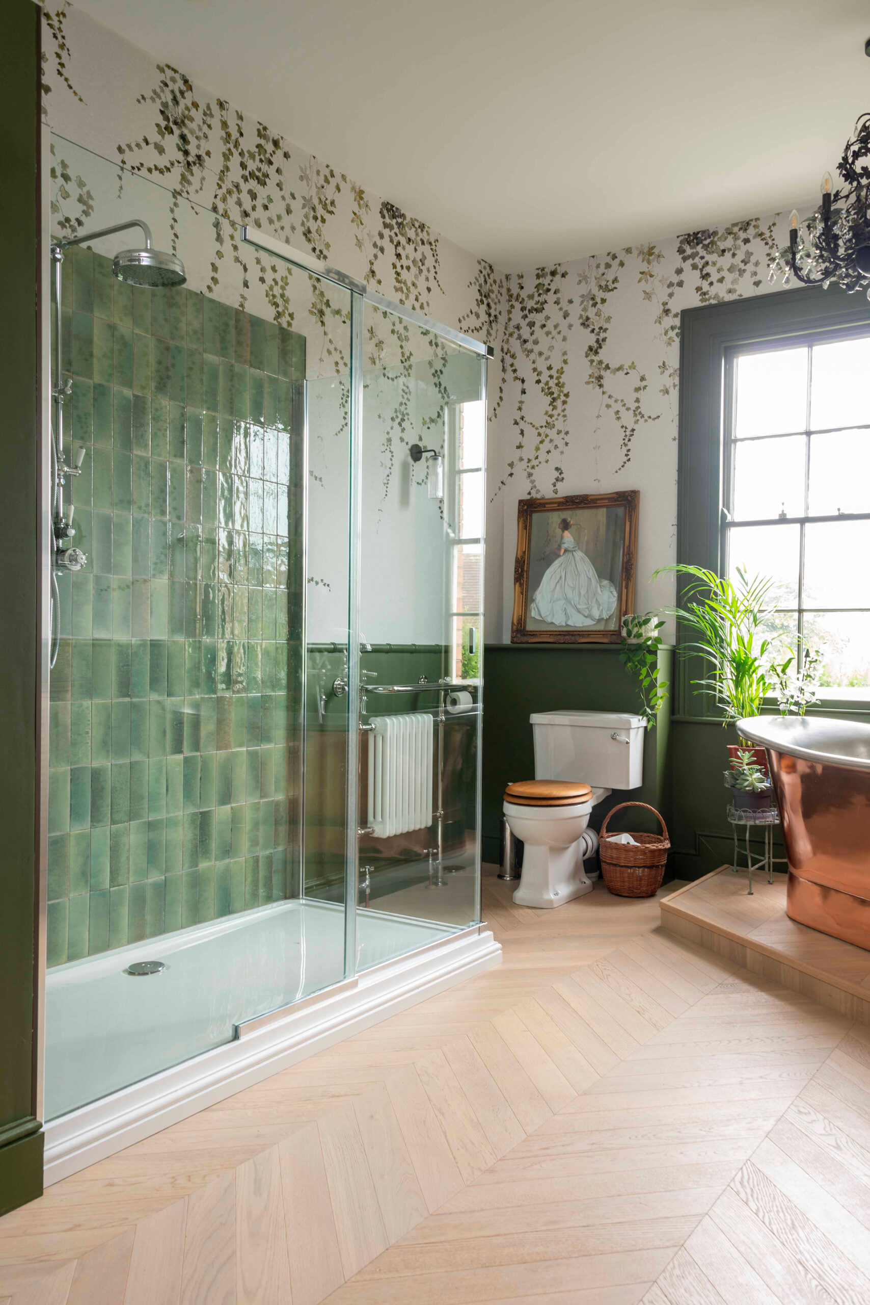 A view into the Georgian Bathroom with chevron oak flooring, green zellige style tiles and a trailing ivy wall mural.