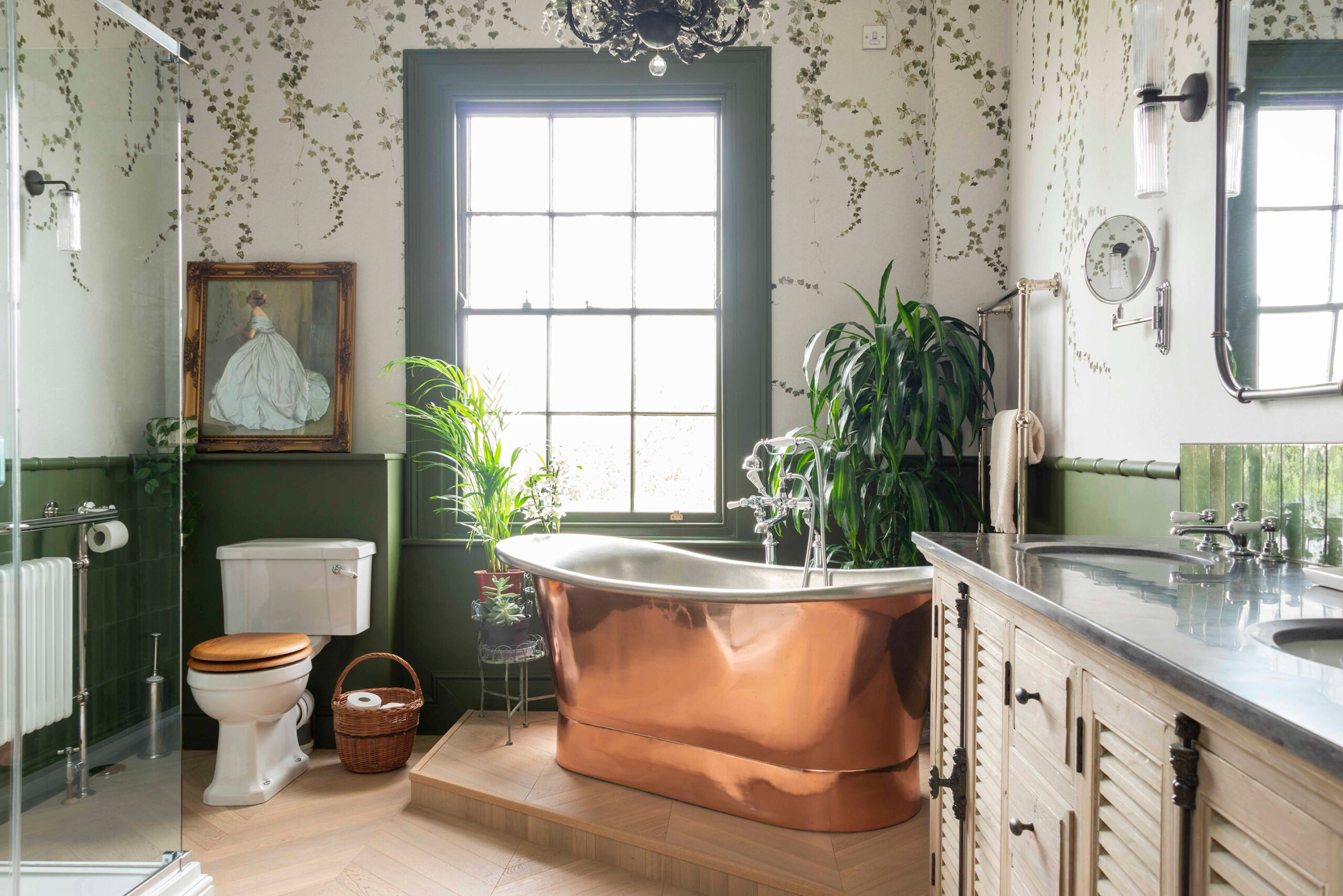 A Georgian bathroom inspired by a traditional glass house design, with lush green foliage, luxurious finishes and rustic, worn touches.