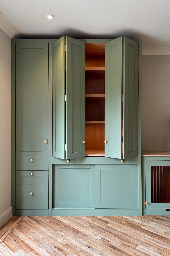 A bespoke home office, with bi-folding doors to hide the workspace and a pull out desk.