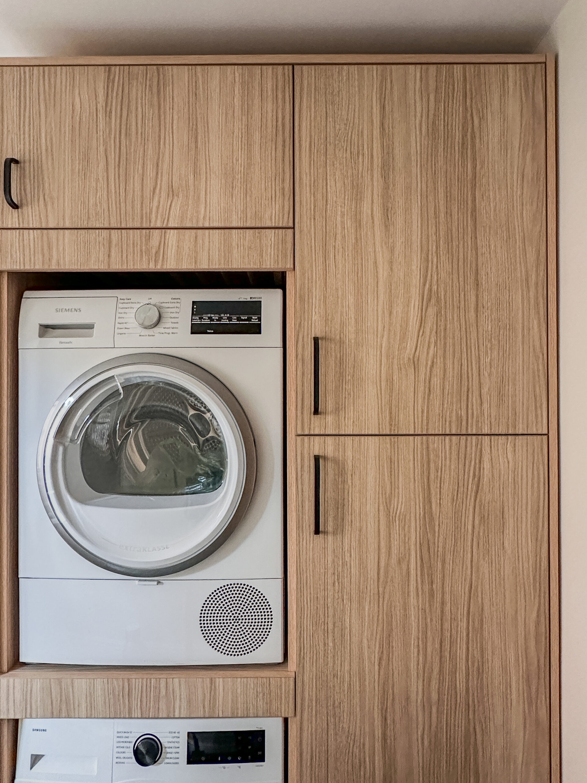 A bespoke utility room with stacked appliances