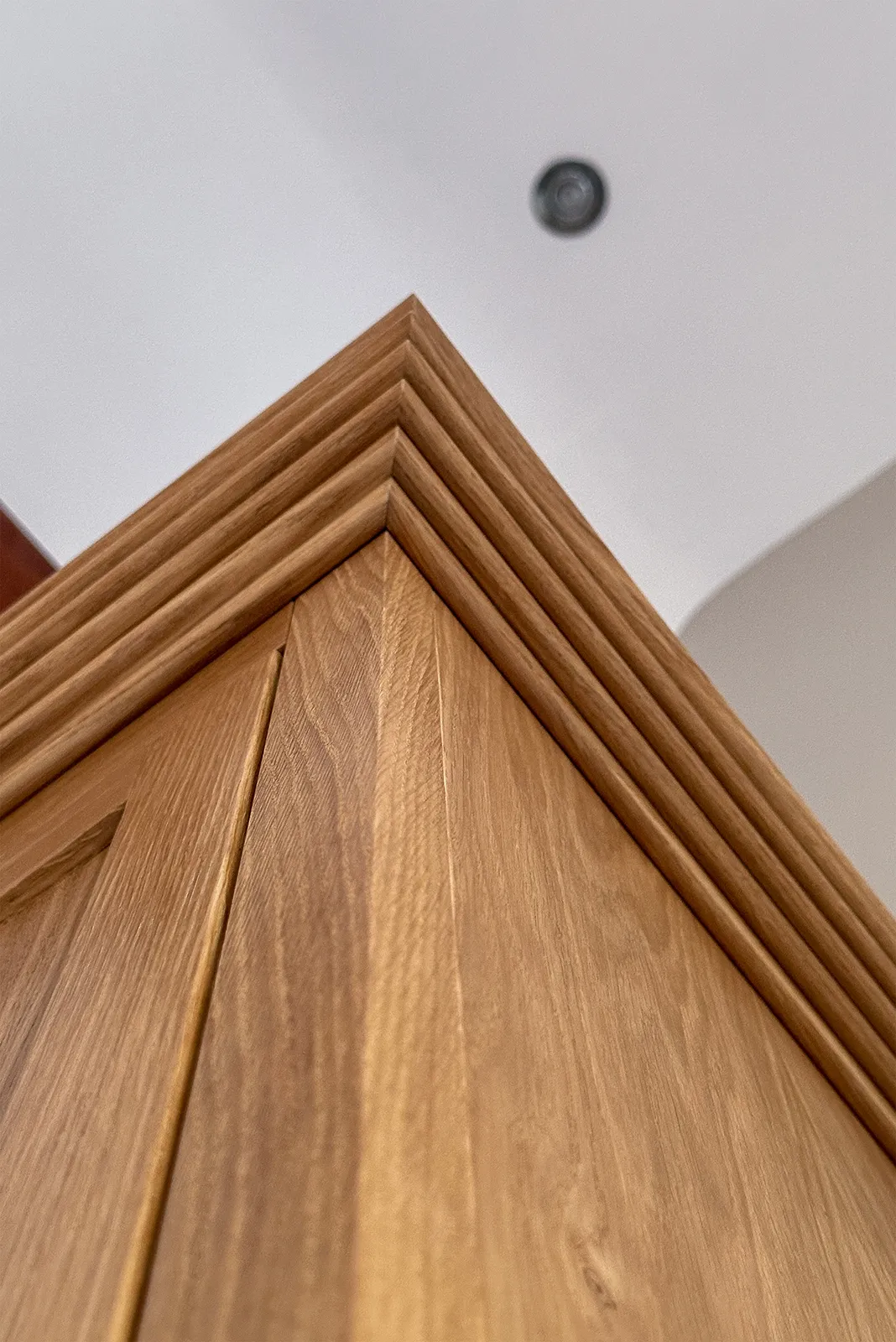 Close-up of the moulded solid oak cornice wrapping around the bespoke wardrobe