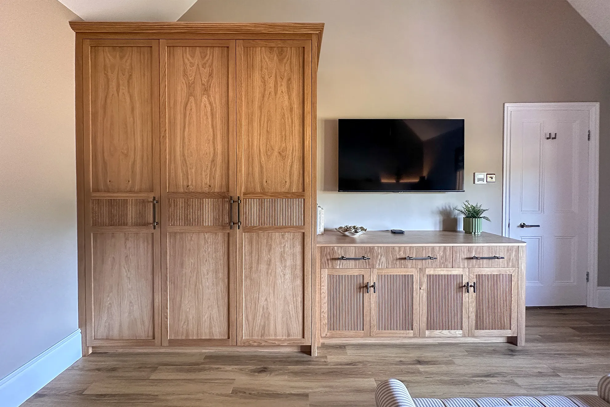 Bespoke oak fitted wardrobes and matching dresser with reeded detailing, designed and made for a vaulted bedroom in Worcestershire.
